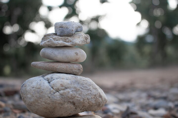 Fototapeta na wymiar Zen Stones / Zen stone on beach for perfect meditation. Calm zen meditate background with rock pyramid on sand