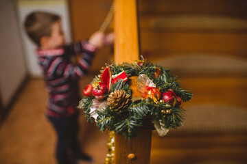 Little boy in decorating stairs for Christmas at home