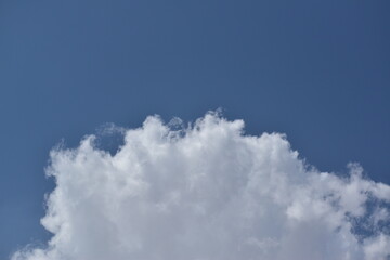 A shot of bright blue sky with puffy white clouds.