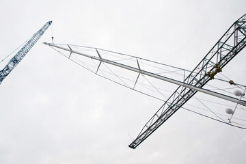 Superyacht. Sailing yacht. Placing of the mast. Cranes. Shipbuilding industry. Mast hanging in crane.