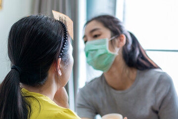 Selected focus on Model for makeup. Makeup artist wearing face mask doing makeup for girl indoor...