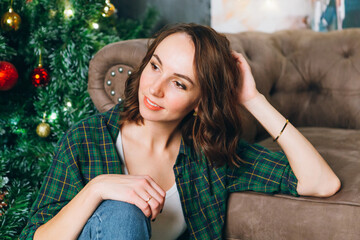 Young beautiful brunette woman at the Christmas tree