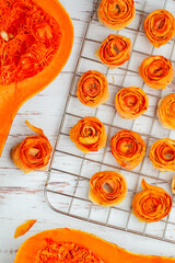 Cooking homemade organic crispy pumpkin chips. Vegetable rose flowers. The concept of delicious and healthy vegetarian and vegan food. Diet snack. Selective focus, top view