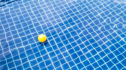 small yellow plastic ball in the pool.