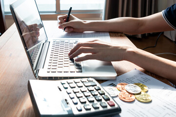 Close up of businessman or accountant hand on calculator to calculate and laptop, working on financial data report. Businessman working with calculator, business document and laptop computer notebook.