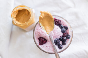 Delicious pink smoothie with red fruits and peanut butter 