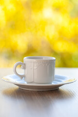 Fototapeta premium coffee mug in a cafe on a wooden table against the background of autumn leaves. Autumn mood.