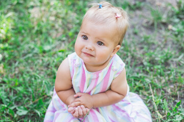 adorable baby in multicolored dress in the park