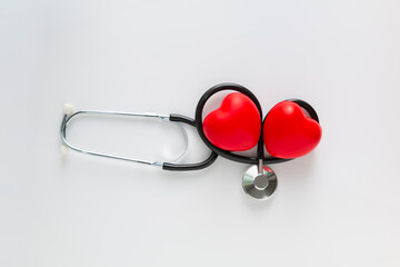 Health insurance concept, Cardiology concept. Red heart and a stethoscope on white desk....