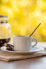 coffee mug in a cafe on a wooden table against the background of autumn leaves. Autumn mood.