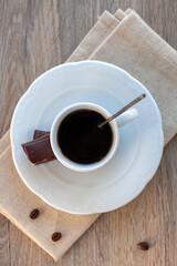 white coffee Cup with chocolate slices on a wooden table. the view from the top