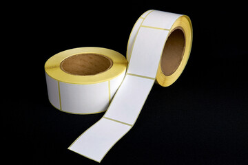 Blank Label Stickers. Babina of self-adhesive stickers on black background. Sticky label roll
