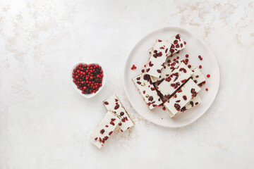 White chocolate cranberry and almond toffee on plate, ready to eat.  Delicious Christmas treat. Top view, blank space