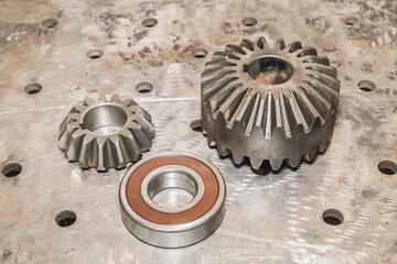 gears and bearing lie on a metal tabletop at the factory