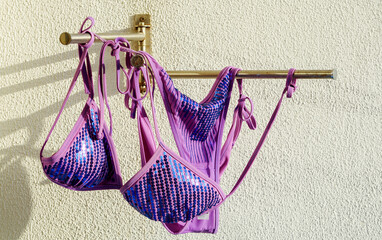 Beautiful women's swimsuit hanging on the dryer