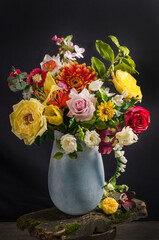 Elegant bouquet of flowers in a vase on a black background in dark style, still life