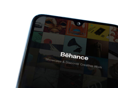 Lod, Israel - July 8, 2020: Adobe Behance app launch screen with logo on the display of a black mobile smartphone isolated on white background. Top view flat lay with copy space. 