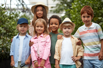 portrait of multi-ethnic children keen on nature, spending time in garden or hothouse, greenhouse. harvest, plants and living beings creatures around