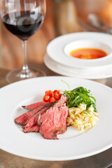 プレートに乗った肉料理と、付け合わせの野菜と赤ワイン