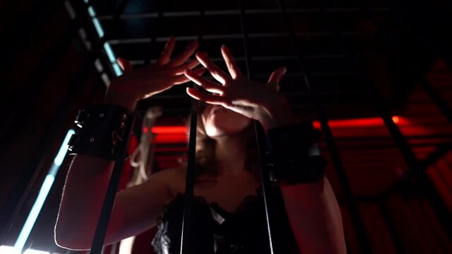 sexy lady is playing with cage for bdsm sex playing, closeup view of hands