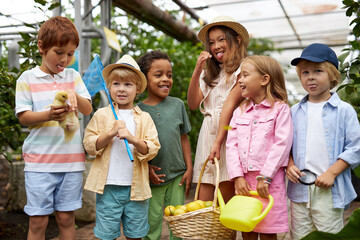 group of diverse kids interested in nature, adorable sweet children spend time in greenhouse or garden, full of plants and living creatures