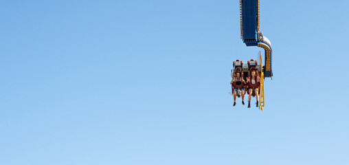 Two excited women at Fabbri Booster attraction against blue sky