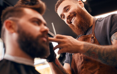 Happy barber cutting hair of customer