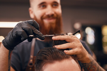 Blurred barber cutting hair of client