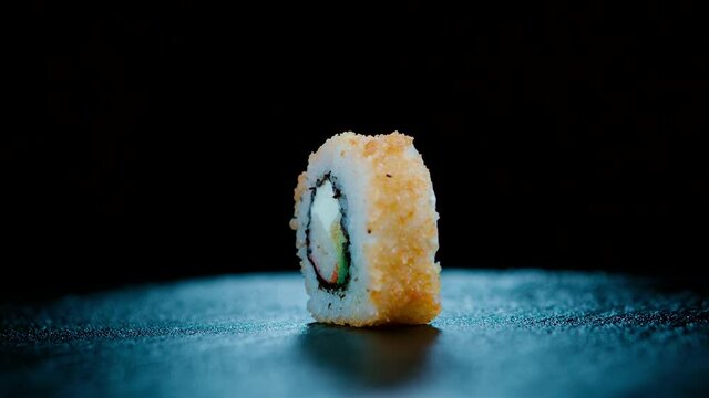 Rol de sushi girando con fuego de fondo. Rol de sushi tempura con fuego de fondo. 240 Fps HD