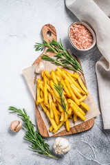 Potatoes fries, French fries with rosemary on a cutting board. White background. Top view