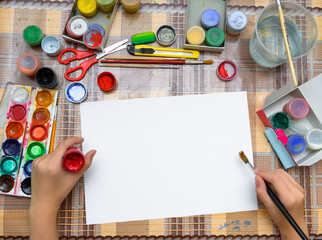 a girl drawing watercolor on a blank white paper, artistic creation at home, makes creative artwork