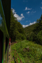 Narrow gauge railway view from train for forests and meadows in Poland mountains