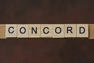 gray word concord made of wooden square letters on brown background
