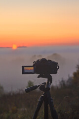 the camera shoots time laps of sunrise on a foggy morning