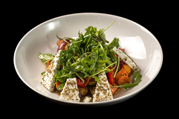 Salad with herbs and cheese in a white plate