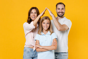 Happy young parents mom dad with child kid daughter teen girl in basic t-shirts holding hands above...