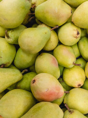 Ripe green pears in a hypermarket for sale. Vertical image.