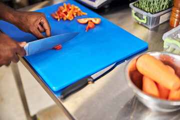 Man cutting vegetables in professional cafe kitchen
