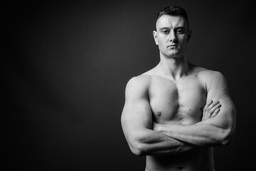 Naklejka premium Young handsome man shirtless against gray background