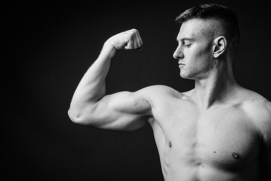 Young handsome man shirtless against gray background