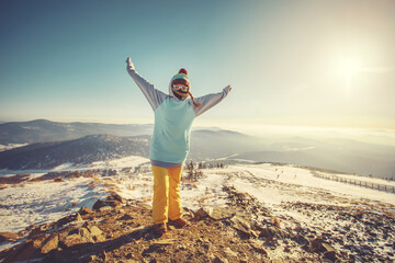Woman standing on the top, admiring winter mountain landscape. Happy tourist woman in winter....