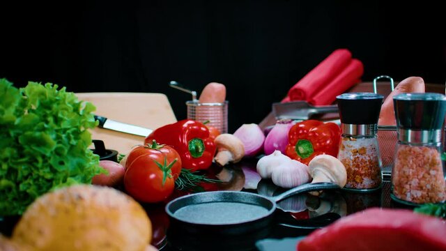 Dolly out por mesa oscura con ingredientes para cocinar  hambueguesas. HD