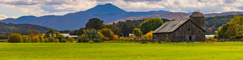 banner of a Vermont farm  with view of Camels Hump Mountain in fall foliage season
