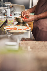 Afro American chef cooking tasty pizza in restaurant
