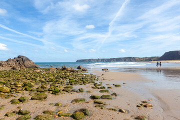 Cliffs and sea rock on a beach, blue sky