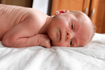 cute newborn child infant with serious face ready to sleep close up