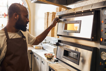 Smiling bearded chef baking dishes in kitchen
