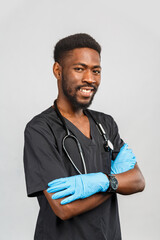 young african or afro american doctor or surgeon with stethoscope and blue gloves standing against gray background