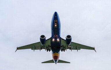 Bottom side of an airplane in the sky on a overcast day