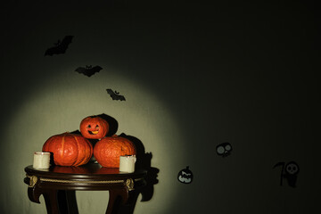 Colored pumpkins on wooden stool in front of a backdrop